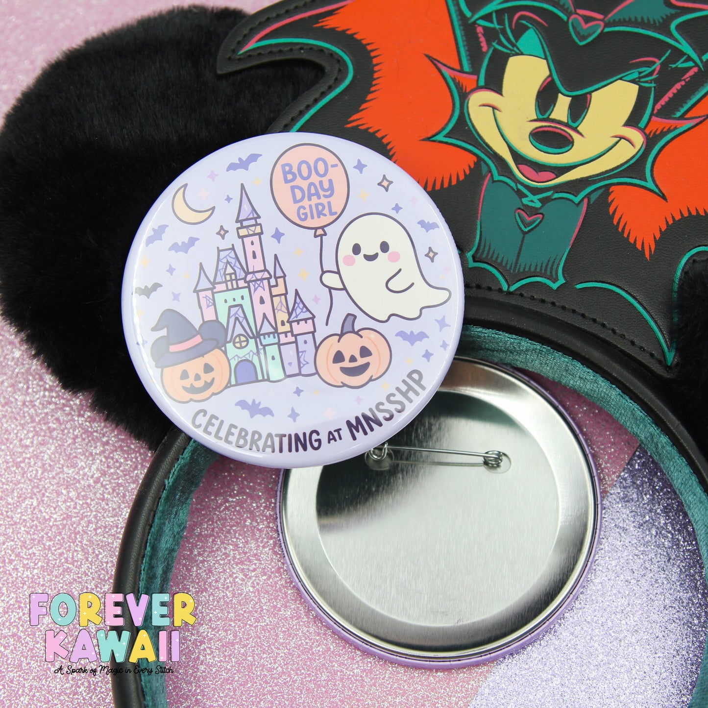 a Halloween-themed button with a cartoon character and a ghost, along with a pinwheel and a black furry object.