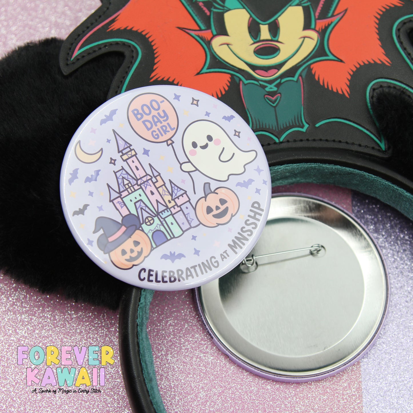 a round pin with a cartoon character and Halloween-themed decorations, such as a ghost, castle, and pumpkins, along with the text "BOO-DAY GIRL" and "CELEBRATING AT MISSISSIPPI".