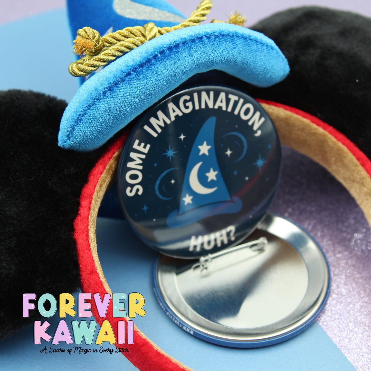A close-up of a blue wizard hat with a pinwheel attached, featuring the text "Some Imagination" and a starry night sky design.
