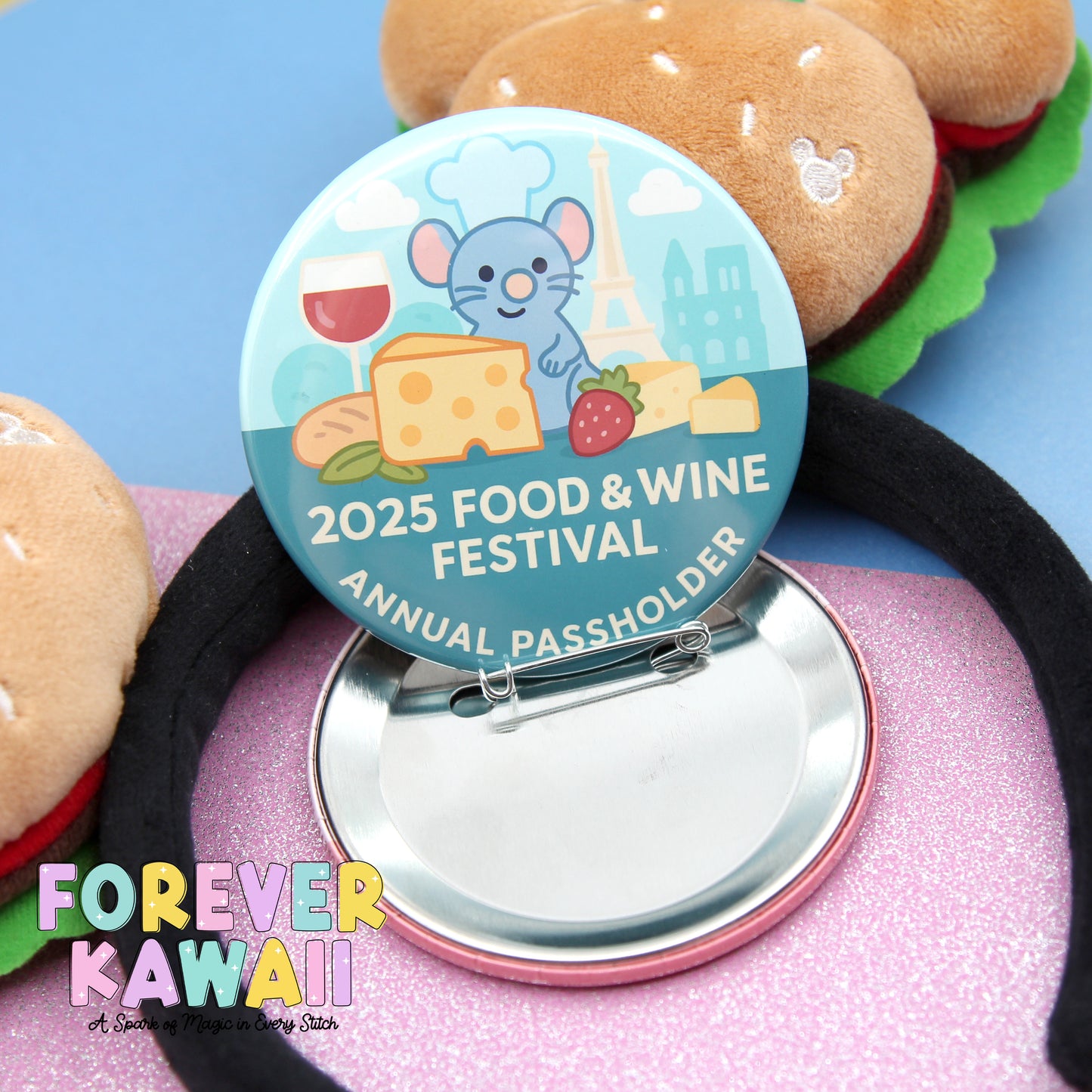 A round pin with a cartoon mouse and various food items, such as cheese and strawberries, is displayed on a pink surface.