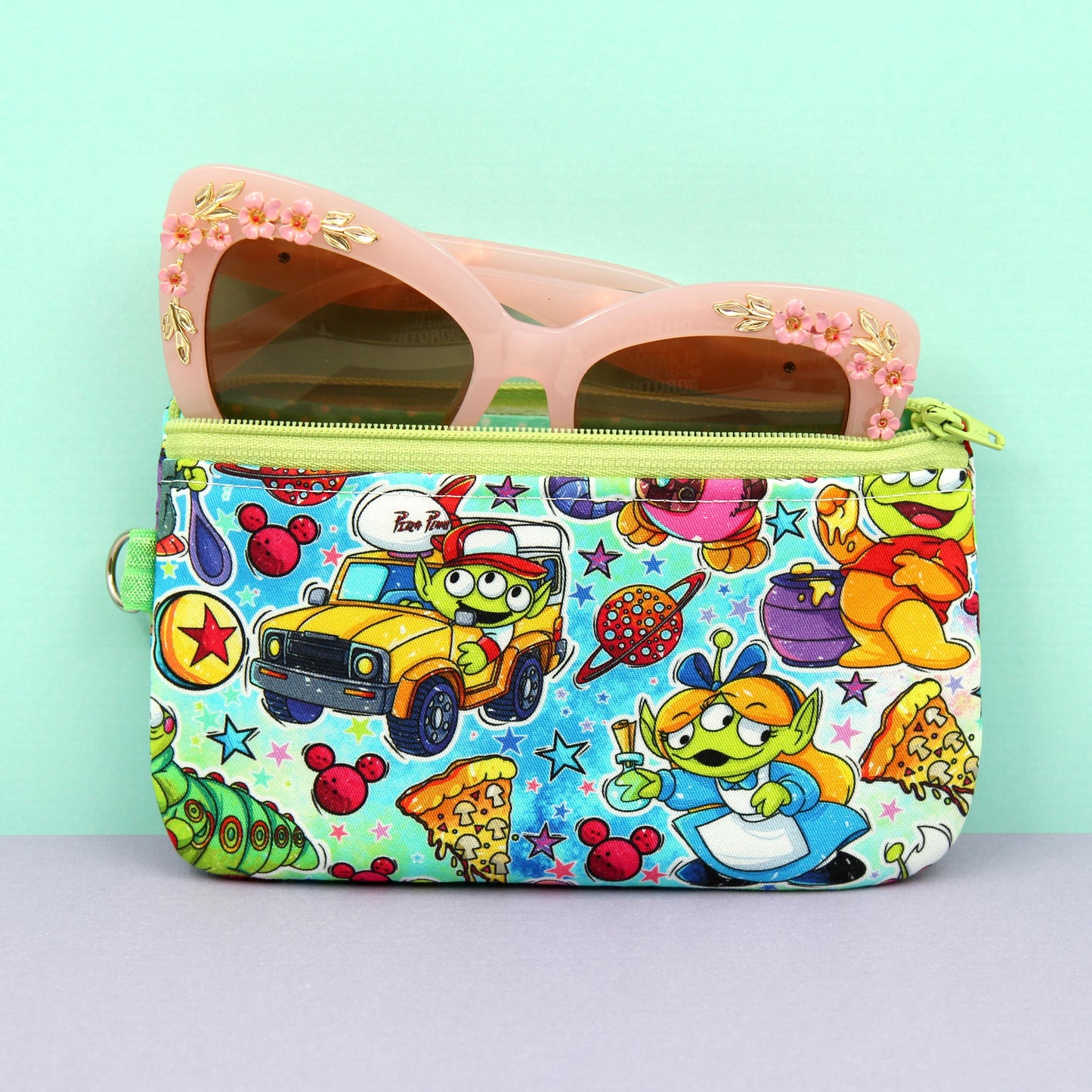 Handmade zipper pouch featuring a Baby Grogu-inspired character enjoying theme park rides, perfect for protecting eyeglasses, sunglasses, makeup essentials, or small travel items.