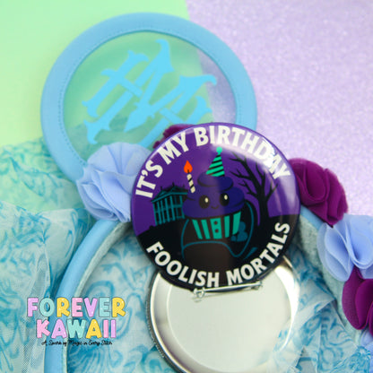 a birthday-themed item with a purple and black design, surrounded by various other items such as a blue headband, a mirror, and some flowers.