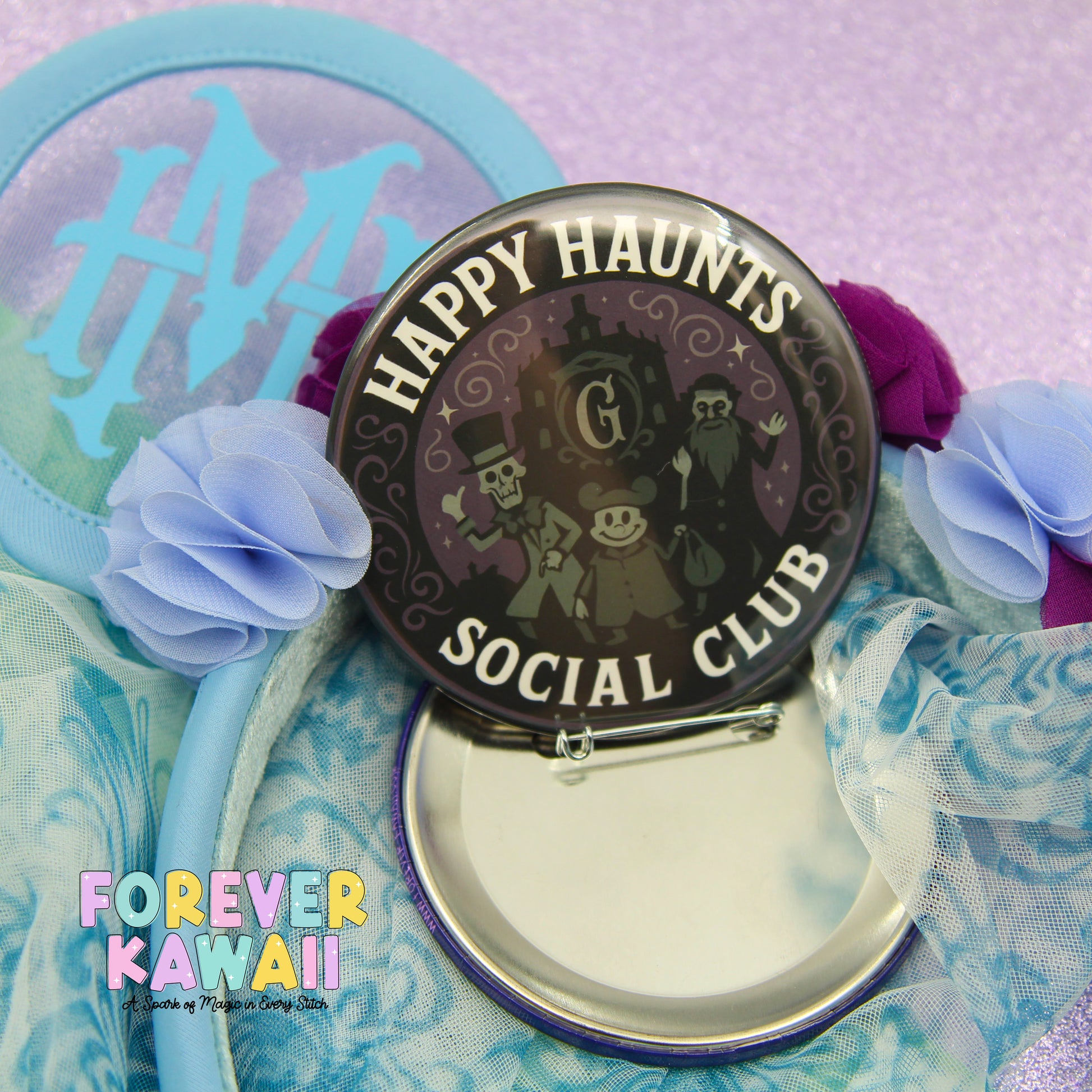 a circular badge with the text "HAPPY HAUNTS SOCIAL CLUB" and a design of a skeleton and a castle. The badge is surrounded by a blue ribbon and a purple flower.