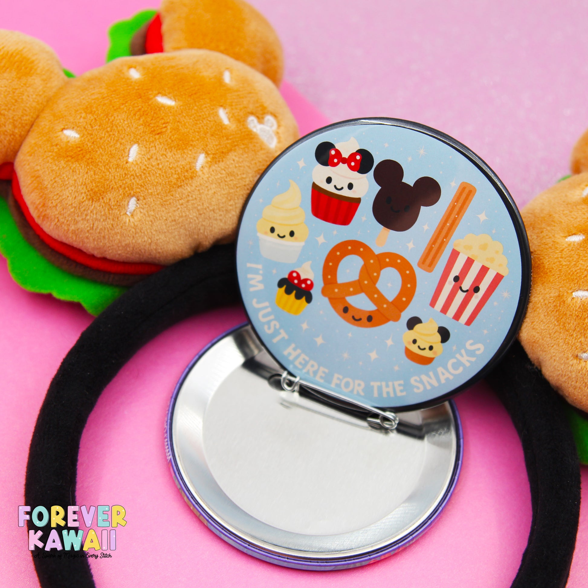 A round mirror with a cartoon character design, surrounded by various snacks and a hamburger, with a black headband in the foreground.
