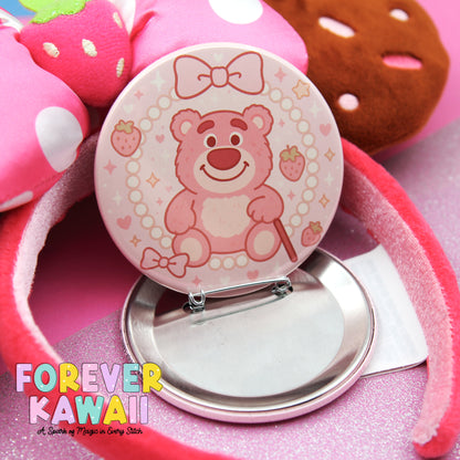 A pink pin-up mirror with a teddy bear design, surrounded by a pink and white polka dot background.