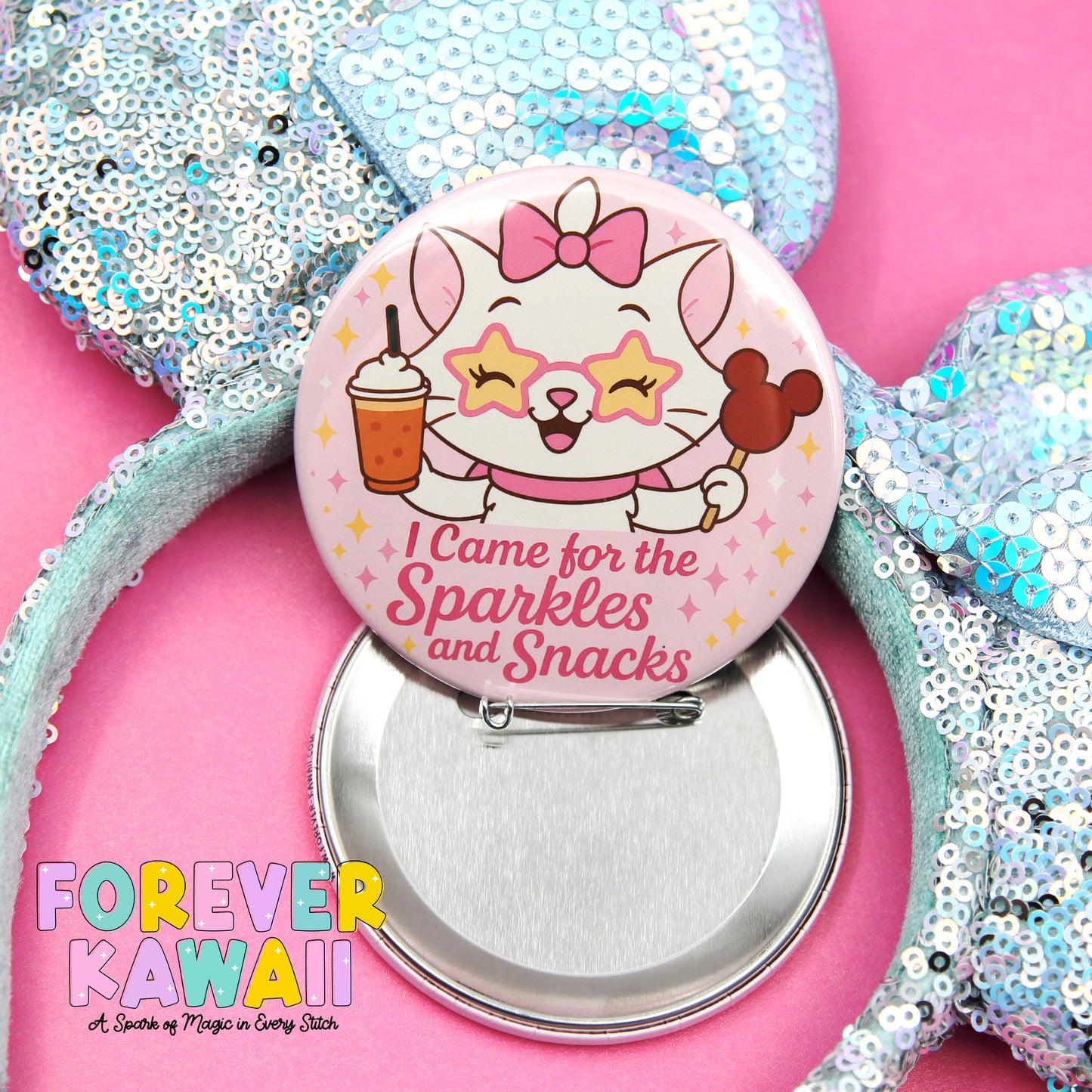 A button featuring a cartoon cat with a bow and a drink, along with the text "I Came for the Sparkles and Snacks" and the Disney character Mickey Mouse. The button is placed on a pink background, and there is a bow and a drink visible in the image.
