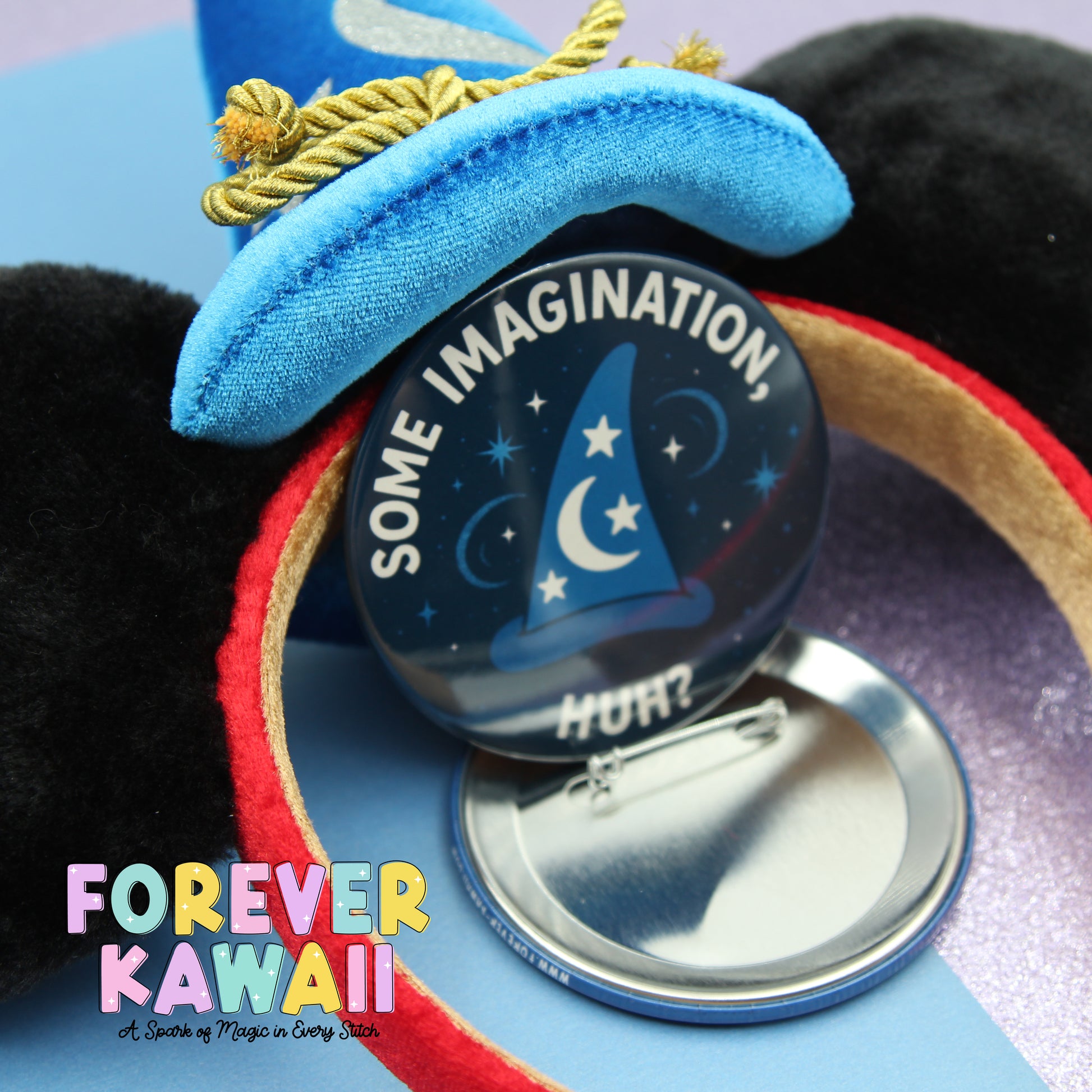 A close-up of a blue wizard hat with a pinwheel attached, featuring the text "Some Imagination" and a starry night sky design.