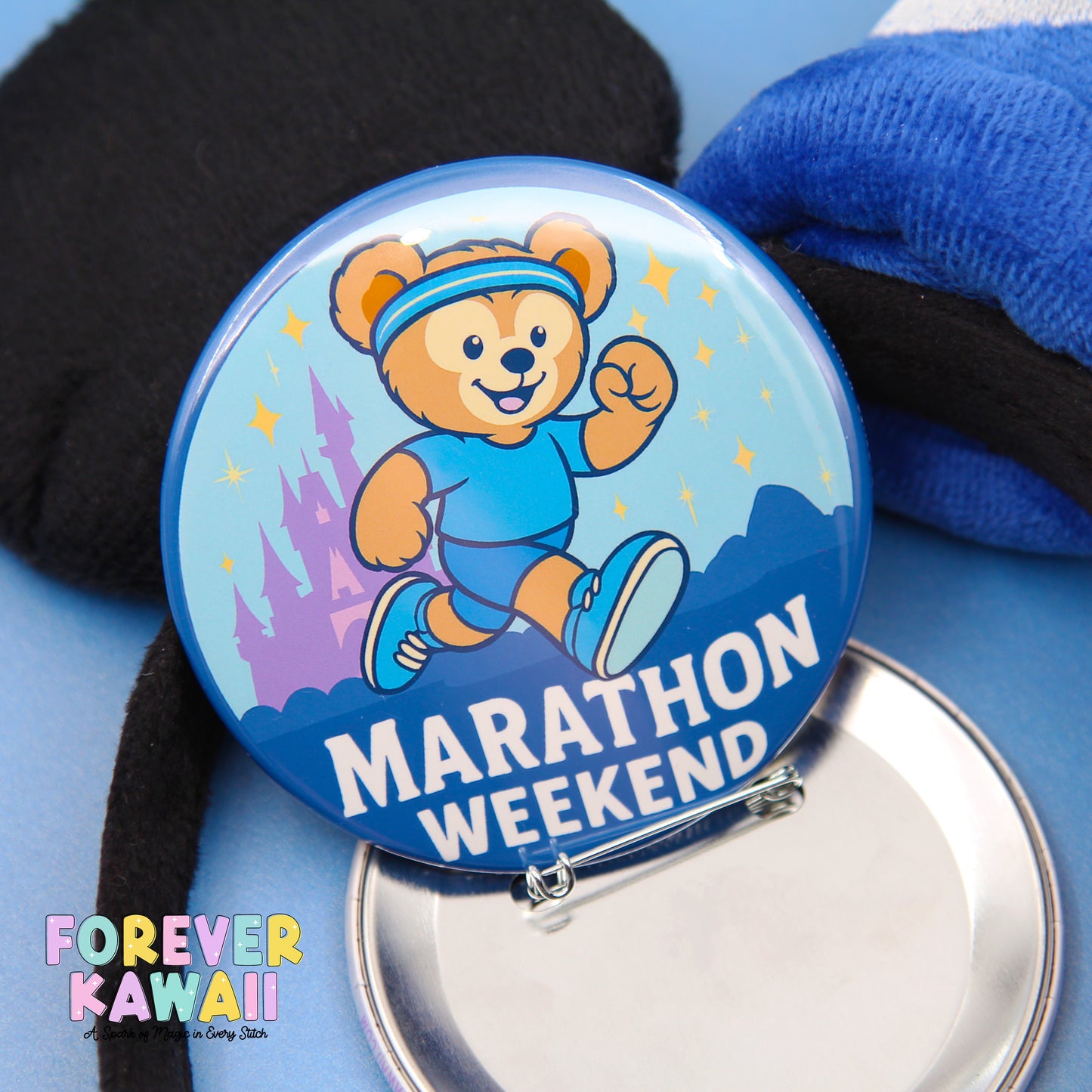 A round pin with a cartoon bear running and the text "Marathon Weekend" on it, along with a blue background and a castle illustration.